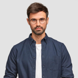 waist-up-portrait-handsome-serious-unshaven-male-keeps-hands-together-dressed-dark-blue-shirt-has-talk-with-interlocutor-stands-against-white-wall-self-confident-man-freelancer waist-up-portrait-handsome-serious-unshaven-male-keeps-hands-together-dressed-dark-blue-shirt-has-talk-with-interlocutor-stands-against-white-wall-self-confident-man-freelancer